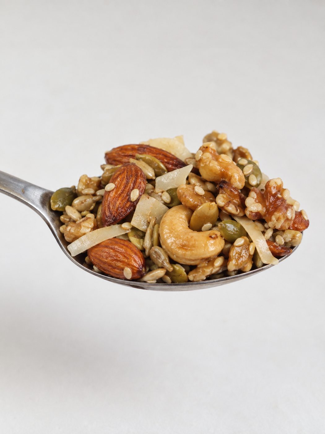 Cuchara con una porción de granola de frutos secos y semillas