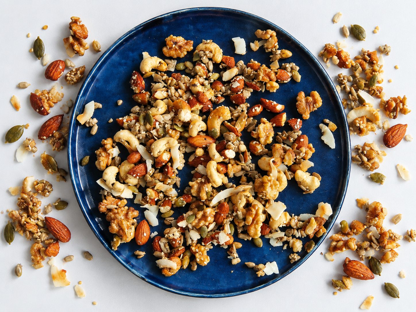 Plato azul con granola de frutos secos y semillas, visto desde arriba